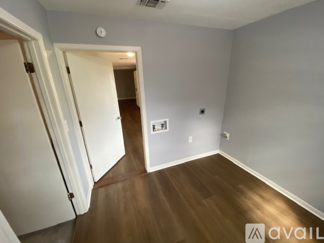 A room with wooden floors and a white door.