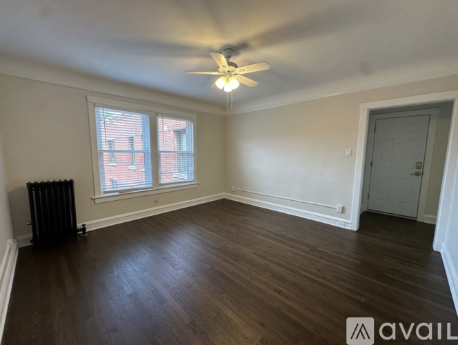 A room with a ceiling fan and wooden flooring.