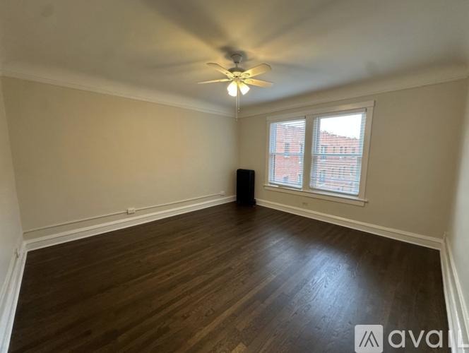 A room with wooden flooring and a ceiling fan.