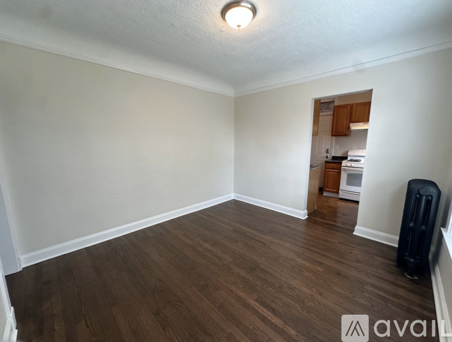 A room with wooden flooring and a speaker on the right side.