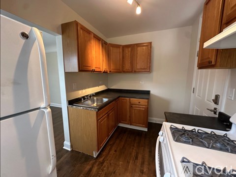 A kitchen with wooden cabinets and a white refrigerator.