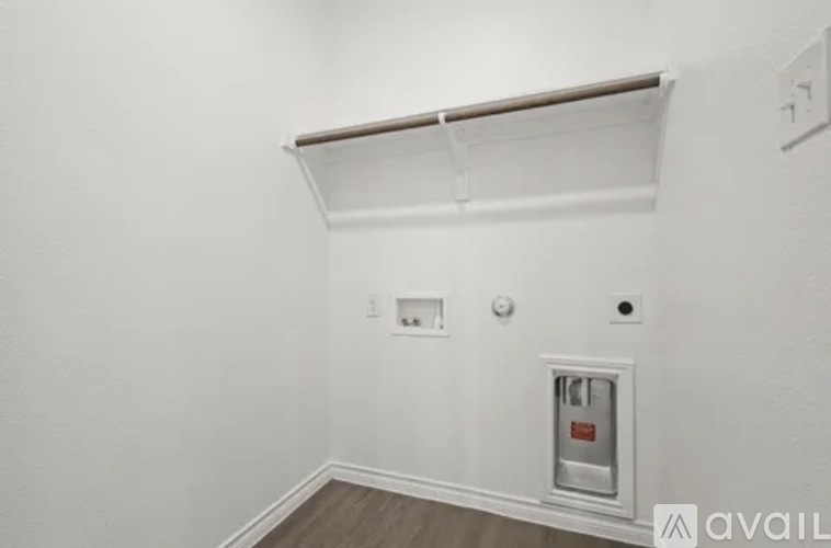 A white wall with a shelf and a small safe box.