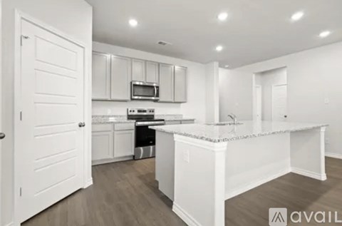A kitchen with white cabinets and a white island.