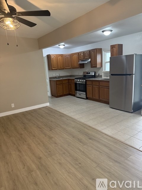 A kitchen with wooden cabinets and a refrigerator.