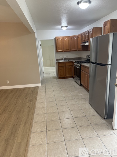A kitchen with a refrigerator, oven, and cabinets.