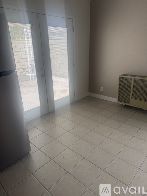 A room with a tile floor and a window with blinds.