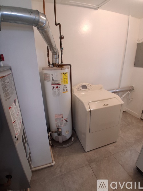 A water heater and a tankless water heater in a bathroom.