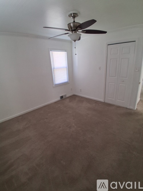 A room with a ceiling fan and a window.