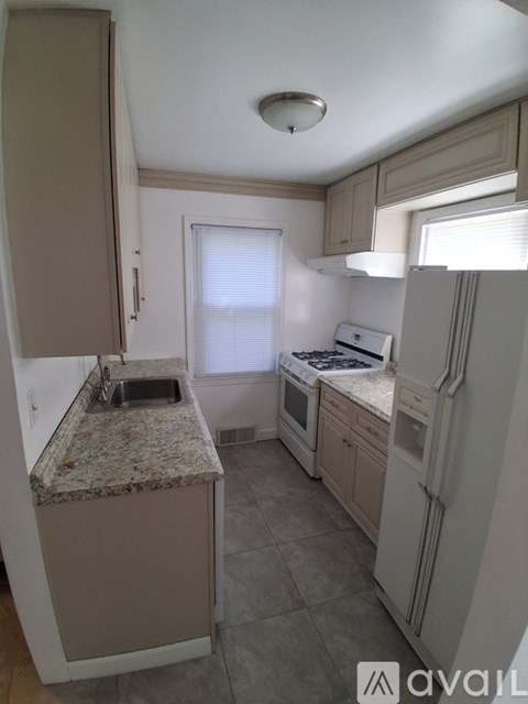 A kitchen with a granite countertop and white appliances.