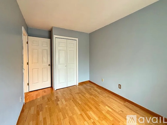 A room with two doors and wooden floors.