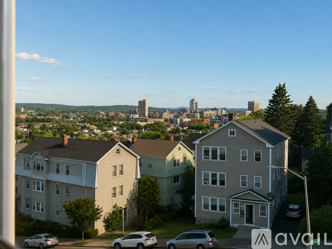 A view of a residential area with houses and cars parked on the street.