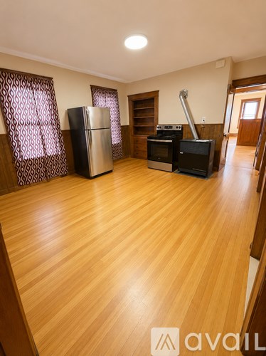 A kitchen with wooden floors and a stove top oven.