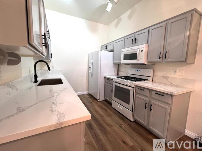 A kitchen with white appliances and cabinets.