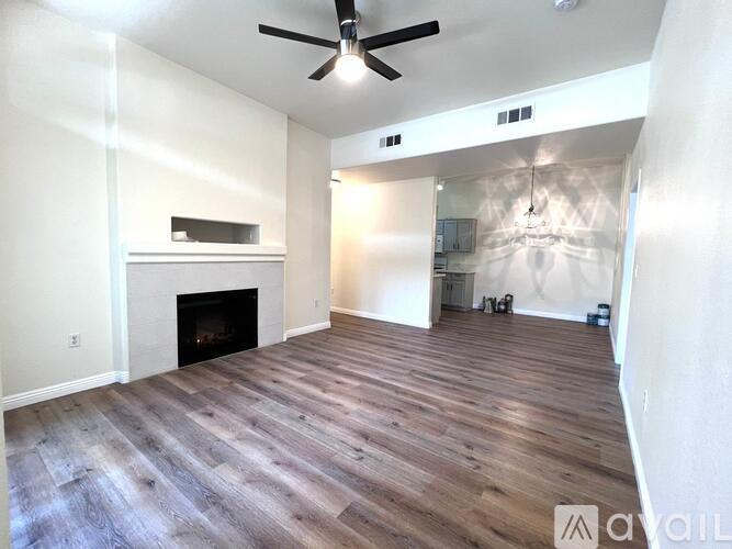 A living room with a fireplace and wood flooring.
