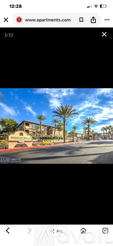 A street view of a residential area with palm trees and apartment buildings.