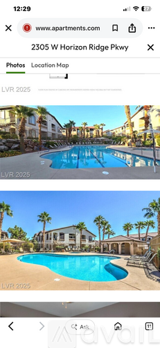 A pool surrounded by palm trees and a building.