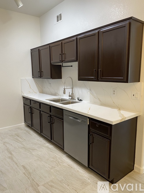 A kitchen with brown cabinets and a marble countertop.