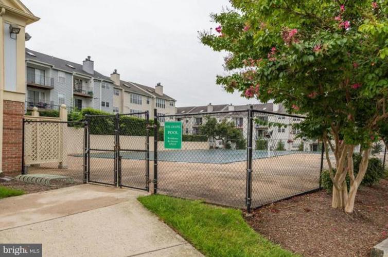 A gated community with a pool and apartment buildings.