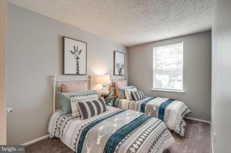 A bedroom with two beds and a window.