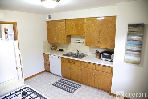A kitchen with wooden cabinets and a white fridge.
