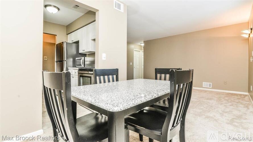 A dining room with a table and chairs.