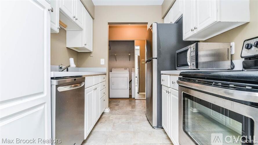 A kitchen with white cabinets and stainless steel appliances.