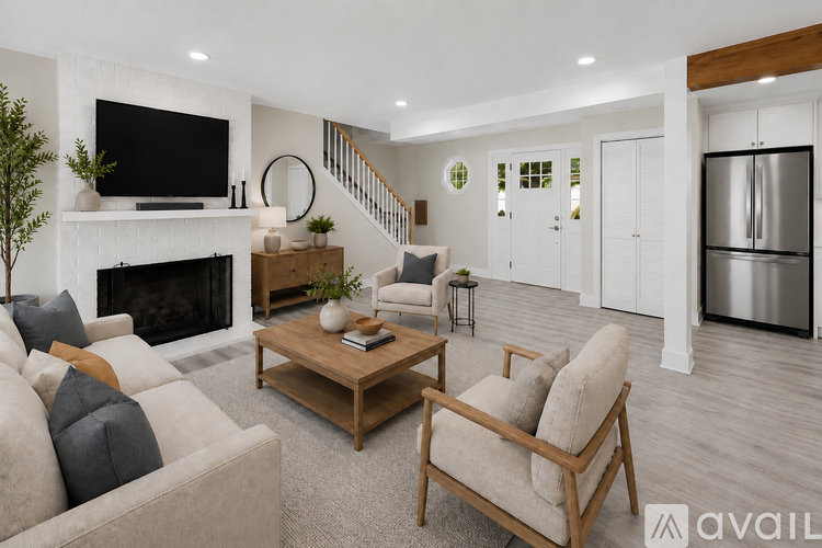 A living room with a fireplace, a couch, a chair, and a television.