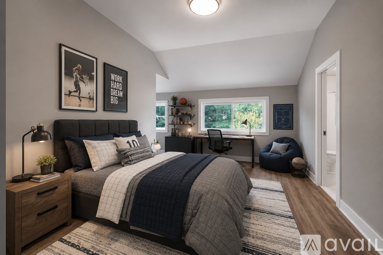 A bedroom with a large bed and a window overlooking trees.