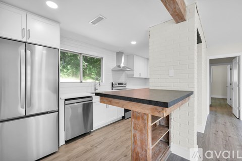 A modern kitchen with a stainless steel refrigerator and a wooden island.