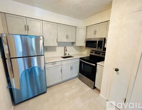 A kitchen with a blue refrigerator and white cabinets.