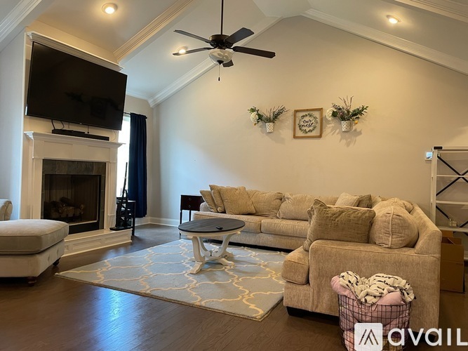 A living room with a couch, a coffee table, a television, and a fireplace.