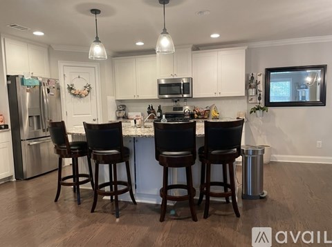 A kitchen with white cabinets and a wooden island.