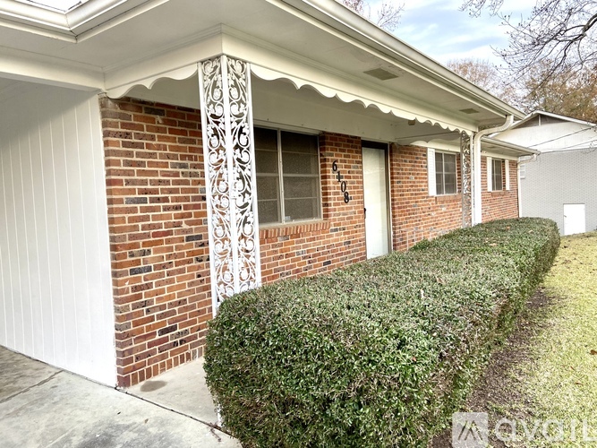A house with a white garage door and a brick wall.