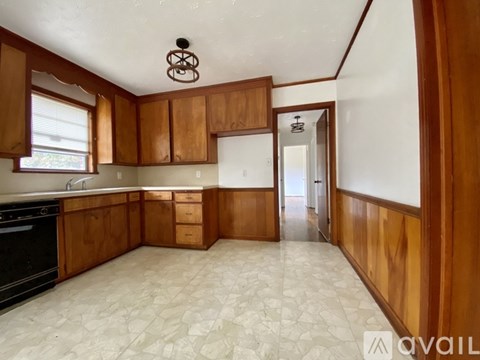 A kitchen with wooden cabinets and a black oven.