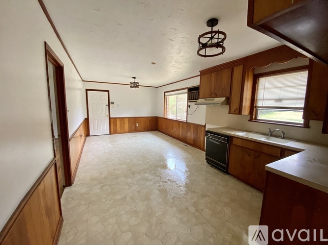 A kitchen with wooden cabinets and a tiled floor.
