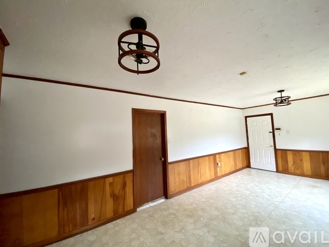 A room with a wooden wall and a white ceiling with a light fixture.