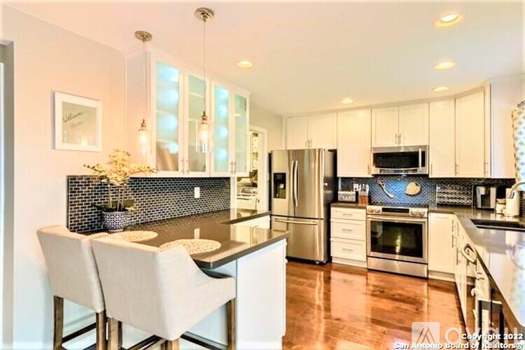 A modern kitchen with white cabinets and a black countertop.