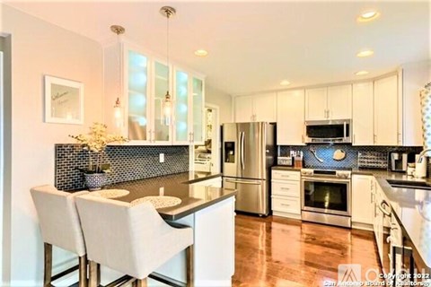 A modern kitchen with white cabinets and a black countertop.
