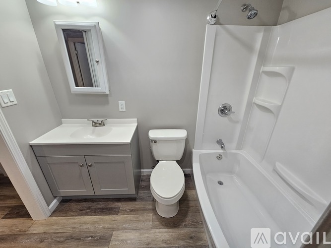 A white toilet sits next to a white sink in a bathroom.