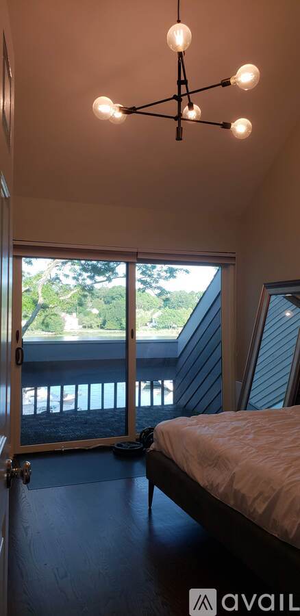 A bedroom with a bed and a window overlooking a deck.