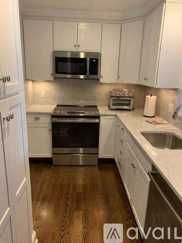 A kitchen with white cabinets and a stainless steel oven.