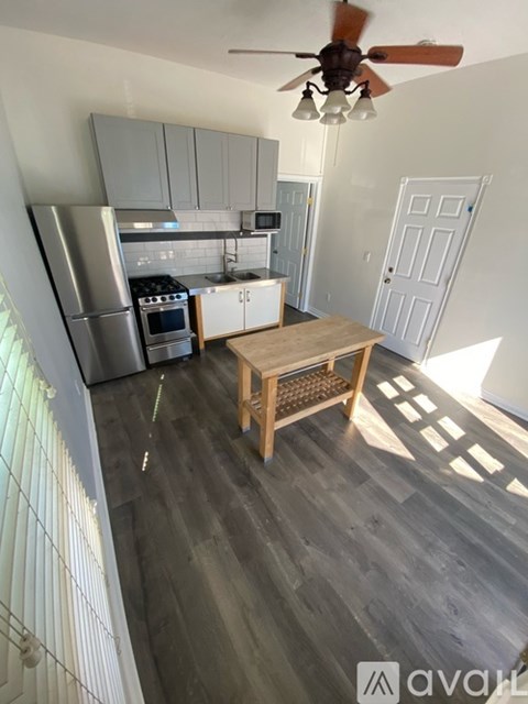 A kitchen with a table and a fan.