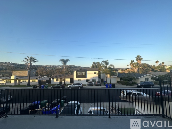 A parking lot with cars and palm trees in the distance.