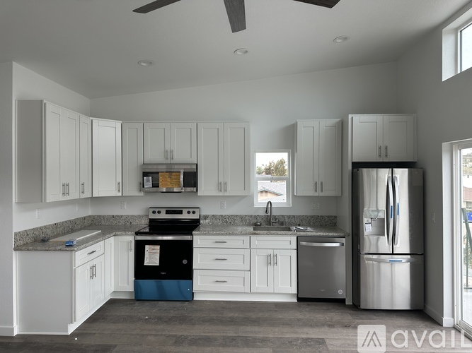 A kitchen with white cabinets and a black stove top oven.