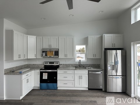 A kitchen with white cabinets and a black stove top oven.