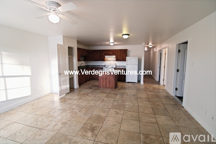 A spacious room with a tiled floor and a ceiling fan.
