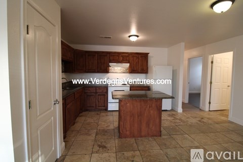 A kitchen with wooden cabinets and a tiled floor.
