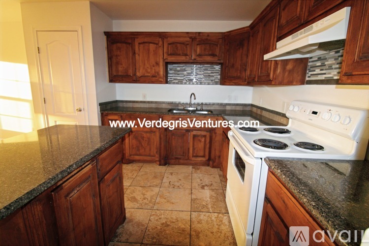 A kitchen with wooden cabinets and a white stove top oven.