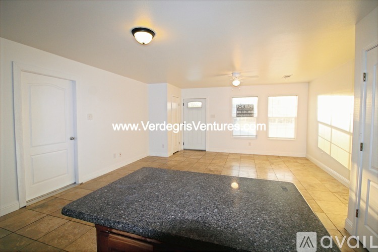 A room with a granite table top and a ceiling fan.