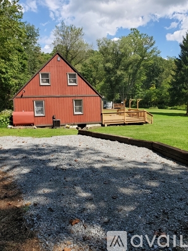 A red house with a wooden deck in front of it.